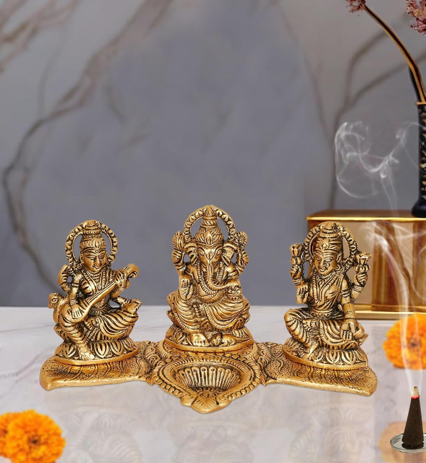 Amazon Brand - Umi Metal Ganesha Lakshmi and Saraswati Idol Metal Sculpture Seated On Peacock Throne Golden Height 4.0 Inches Width 7.5 Inches Medium